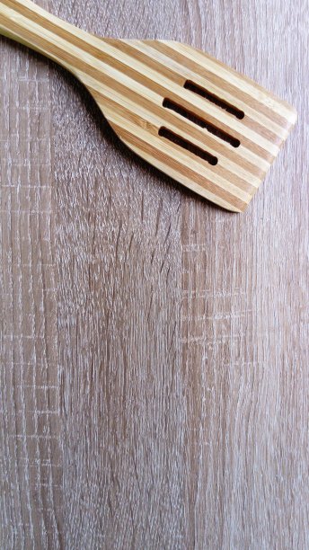 在厨房的木制桌子上做饭用的木铲。自然采光。表面上的主题。两个木头纹理。本空间图片下载