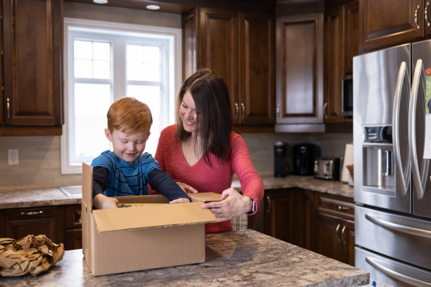 母亲和儿子在家里接收和打开一个包裹图片下载