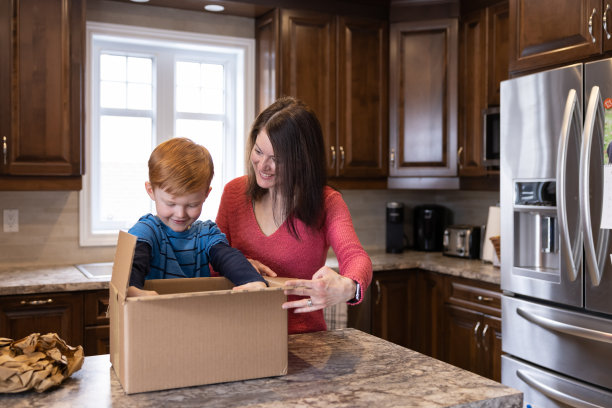 母亲和儿子在家里接收和打开一个包裹图片下载