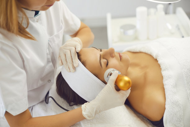 美容师在美容院为女性制作仪器录音面部程序图片下载