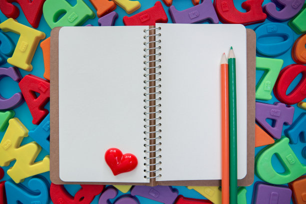 螺旋笔记本上的多色字母块背景图片下载