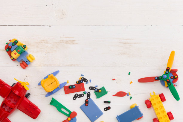 俯视图上的彩色玩具砖在一个白色的木制背景。玩具在桌子上图片下载