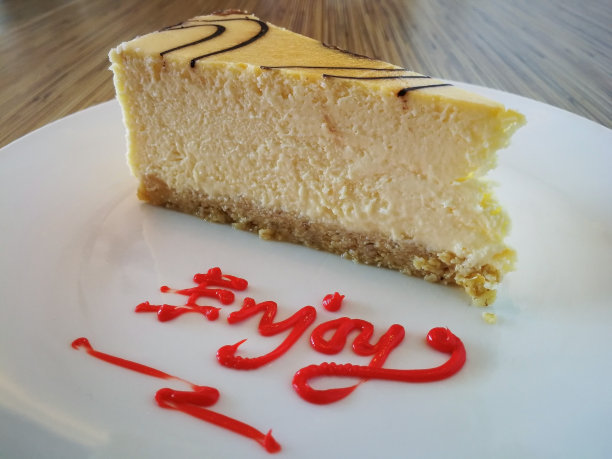 一片普通的大理石芝士蛋糕和享受文字在白色盘子上的木制背景图片下载