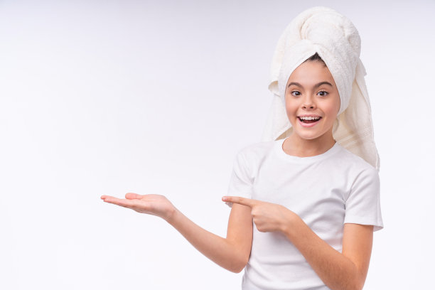开朗美丽的少女在浴巾指着复制空间孤立的白色背景图片下载