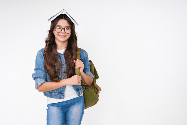 微笑聪明的白人女学生与一本书在她的头孤立在白色的背景图片下载