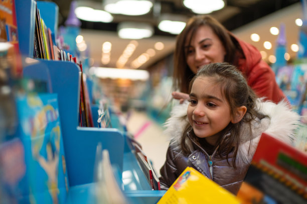 小女孩和妈妈一起逛书店的时候非常开心素材图片