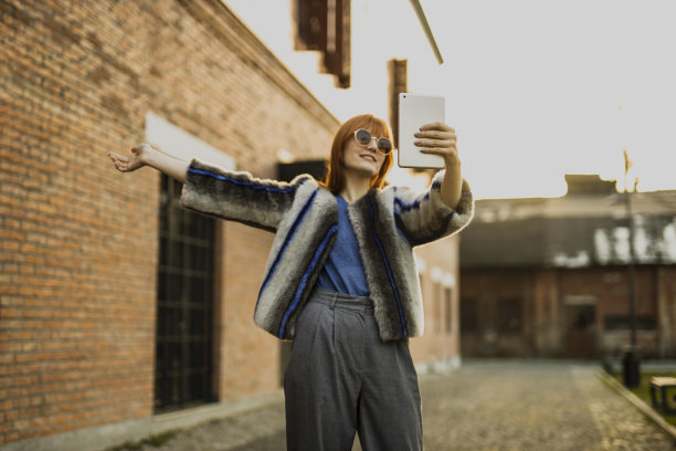 女时装模特在街上用平板电脑自拍图片下载