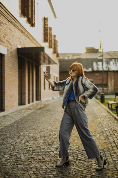 女时装模特在街上用平板电脑自拍图片下载