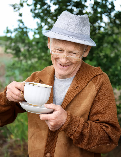 一位老人在户外喝茶。图片下载