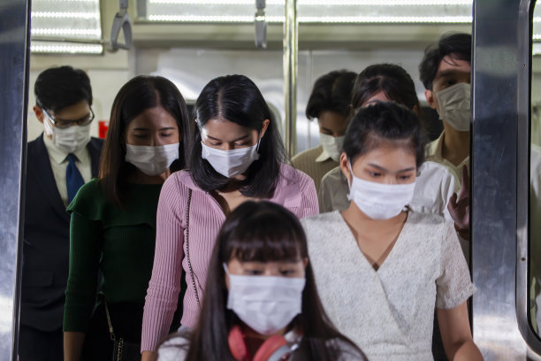 一群晚上下地铁出行的亚洲乘客，每个人都戴着口罩，以应对新常态下的污染和新冠肺炎图片下载