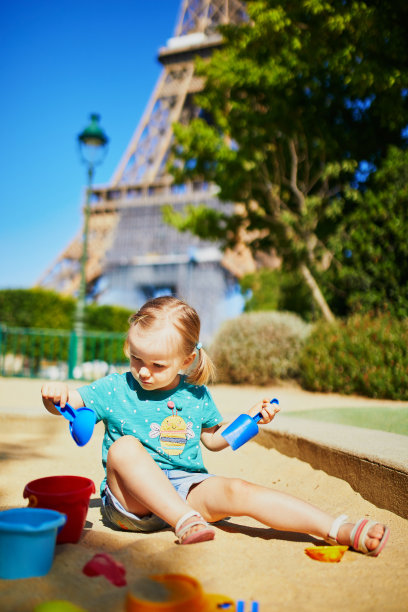 可爱的小女孩在操场上玩在埃菲尔铁塔附近的沙坑图片下载