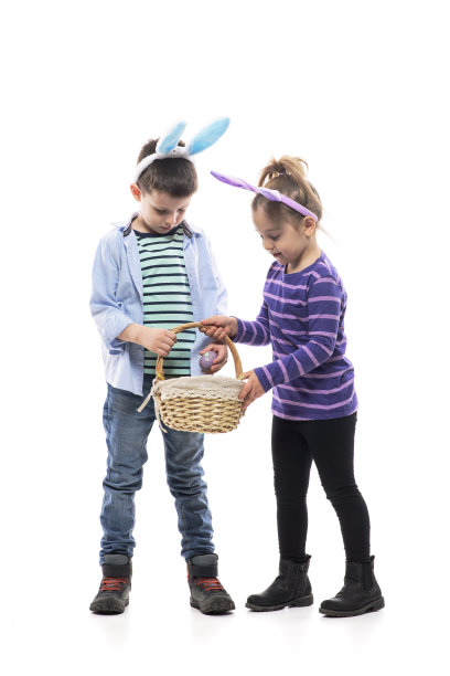 可爱的小女孩和小男孩提着篮子寻找复活节彩蛋的传统。图片下载