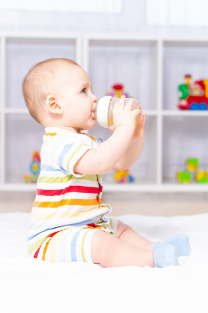可爱的白人男婴喝着奶瓶。图片下载