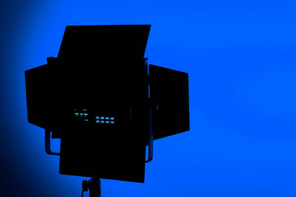 一个LED舞台灯与保护百叶窗在蓝色背景，复制空间图片下载