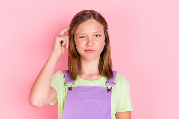 照片肖像的小女孩有疑问不确定孤立在柔和的粉红色背景图片下载