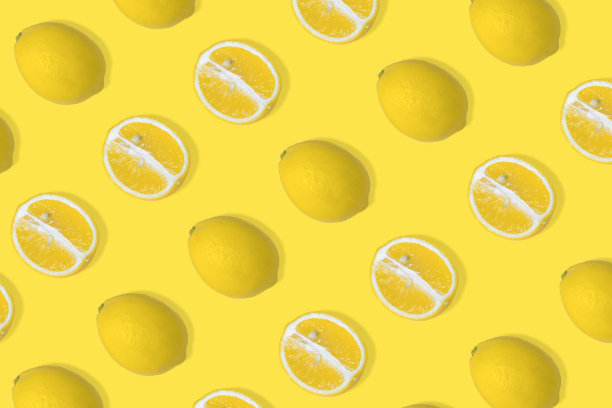 时尚的夏季图案与黄色柠檬片和整个柠檬照亮黄色的背景。图片下载