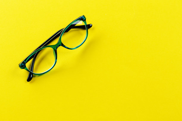 在黄色背景下矫正视力的时尚眼镜。时尚的配件。空间的文本。图片下载