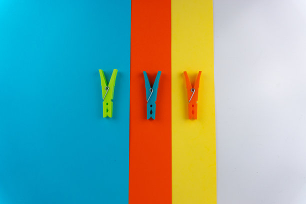俯视图三种不同颜色的塑料衣夹的背景与四种不同的颜色图片下载
