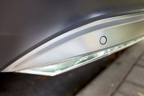 选择性关注左后保险杠停车传感器在豪华汽车保险杠的后面近距离与copyspace瓷砖背景。图片下载