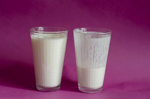 粉红色背景下的满杯和半杯开菲尔酒。图片下载