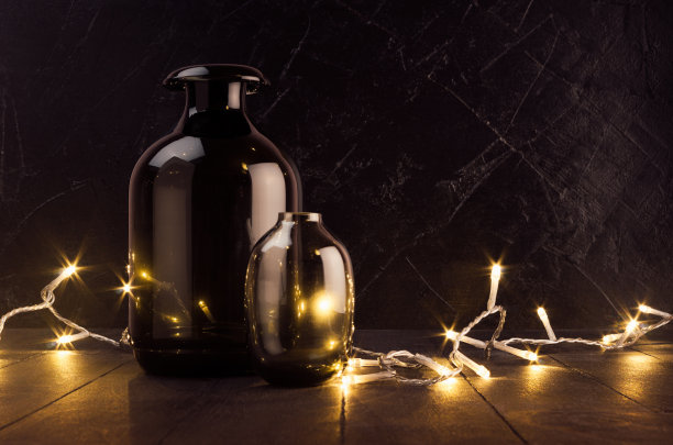 丰富的节日家庭装饰，简单的现代风格，黑色和金色的颜色-温暖的灯在深色的木板和玻璃花瓶发光。图片下载