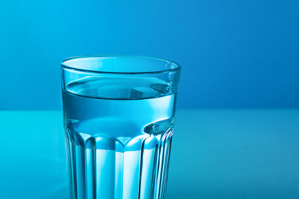 一个有蓝色背景的水的杯子。图片下载