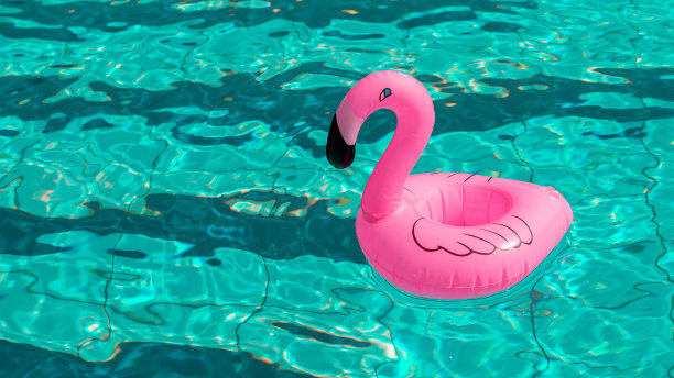 火烈鸟图标。粉红色的充气火烈鸟在游泳池的水为夏天的海滩背景。时尚的夏天的概念。图片下载