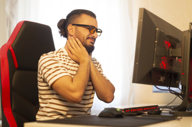 年轻的运动员对着电脑脖子和关节痛。。图片下载