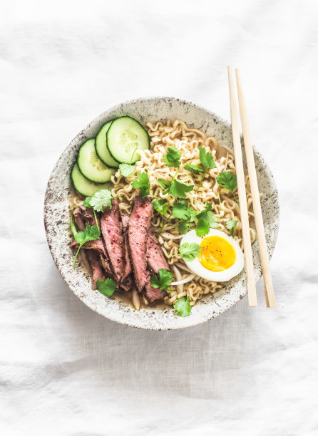 牛扒、鸡蛋、香菜拉面，背景较亮，俯视图。亚洲风格的食物图片下载