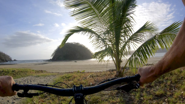 一名男子在早上骑着山地车沿着沙滩行驶图片下载