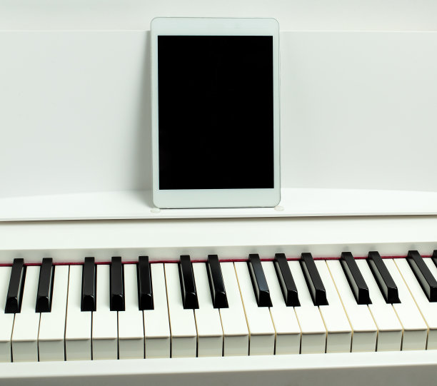 黑白琴键，平板电脑。在线乐器课程的概念图片下载