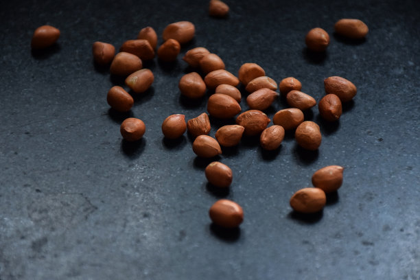 在厨房的自然光下，棕色生花生保存在黑色花岗岩上的库存照片。关注对象。图片下载