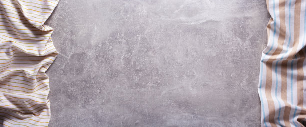 铺在石头或大理石表面的折叠台布。俯视图作为全景布餐巾纹理背景图片下载