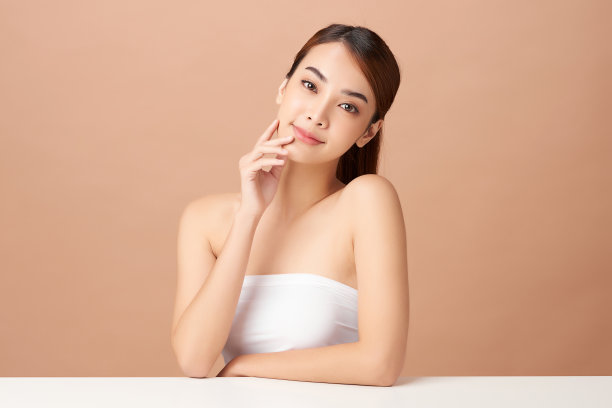 美丽的年轻亚洲女人与干净新鲜的皮肤米色背景，面部护理，面部治疗，美容，美容和水疗，亚洲女性肖像。图片下载