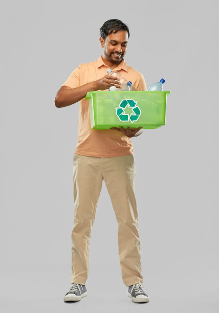 微笑的印度年轻人正在分类塑料垃圾图片下载