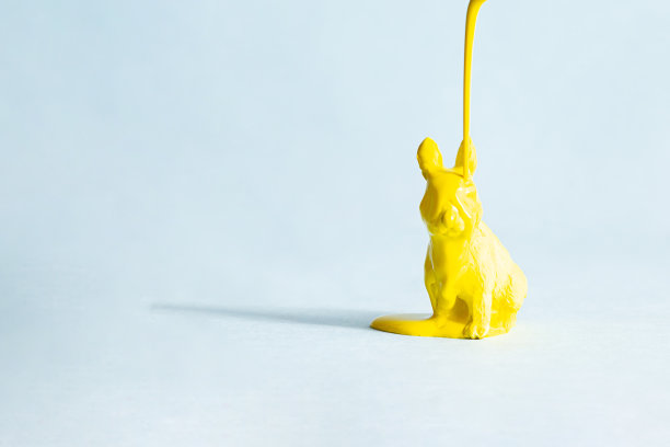 黄色复活节兔子在蓝色的背景上。现代复活节概念，复制空间。最小的创意明信片布局。图片下载