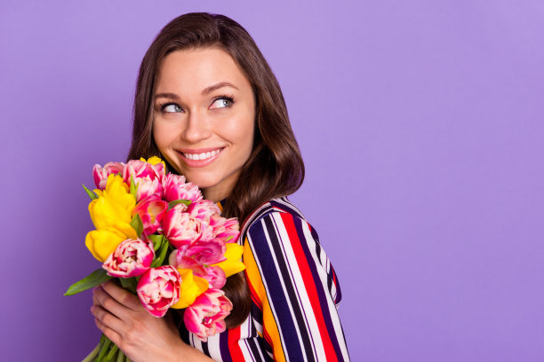 照片肖像的女孩保持鲜花花束梦幻的copyspace条纹彩色衬衫孤立充满活力的紫色背景图片下载