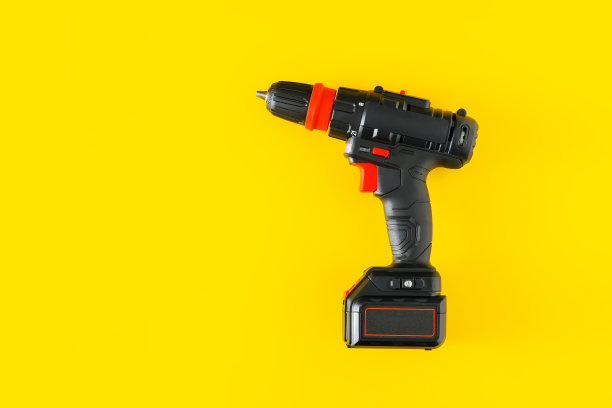 手持无绳电钻黄色背景图片下载