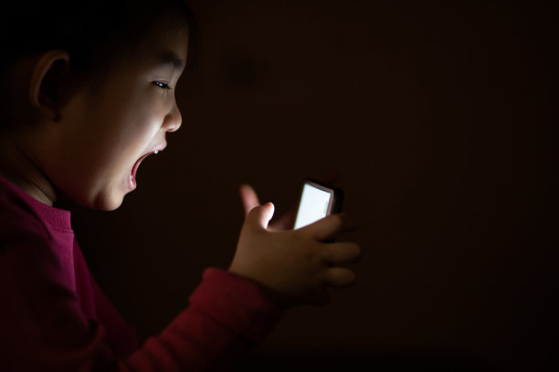 小女孩在暗室里使用智能手机图片下载
