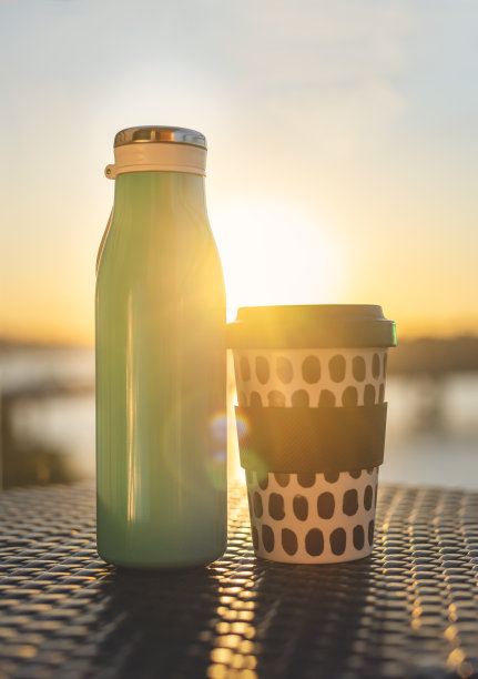 金属可重复使用的水瓶和竹可重复使用的杯子在阳光下。图片下载