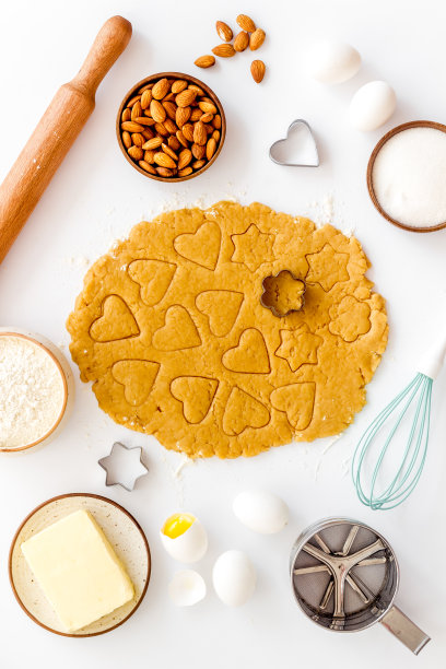 用擀面杖擀面团。心形的饼干切出来。俯视图图片下载