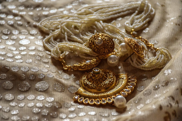 一个美丽的白色珍珠项链与黄金垂饰和耳环的白色背景，传统的印度时尚珠宝，聚焦在班加罗尔城市卡纳塔克邦的对象照片。图片下载