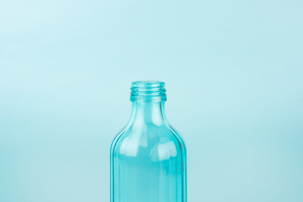 蓝色的玻璃瓶。孤立在蓝色背景。可重复使用容器的概念图片下载