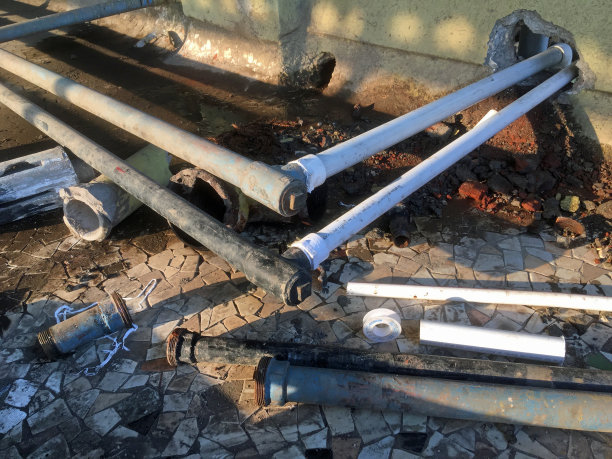 建筑供水，新PVC塑料管，旧金属管和沟渠生锈的物体图片下载