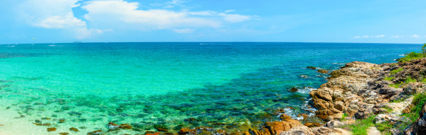 深蓝色的大海和天然岩石的全景。与船在海上航行，与云在日光。在泰国度假的海滩旅游图片下载