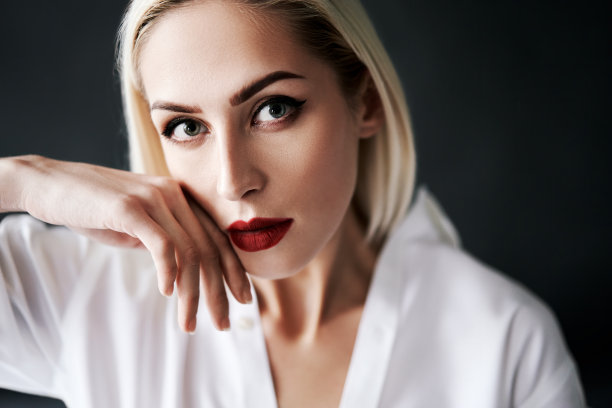 近距离的美丽的金发女人的肖像在优雅的白衬衫摆出孤立的黑色工作室背景红色的嘴唇图片下载