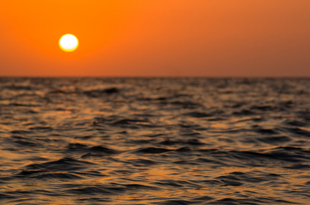 卵石滩上惊人的海上日落，太阳，海浪，云彩图片下载