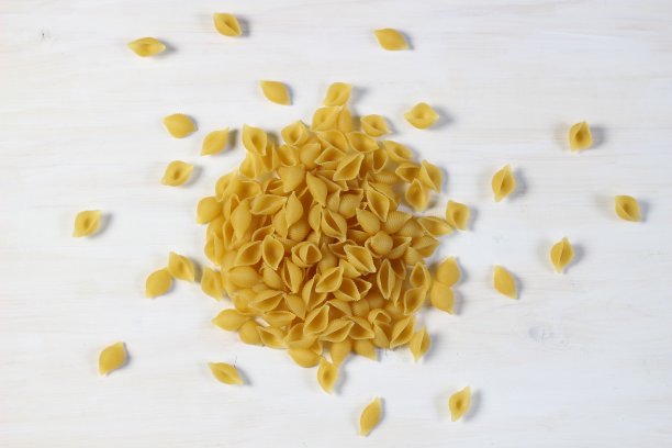 白木色背景上的生贝壳意面图片下载