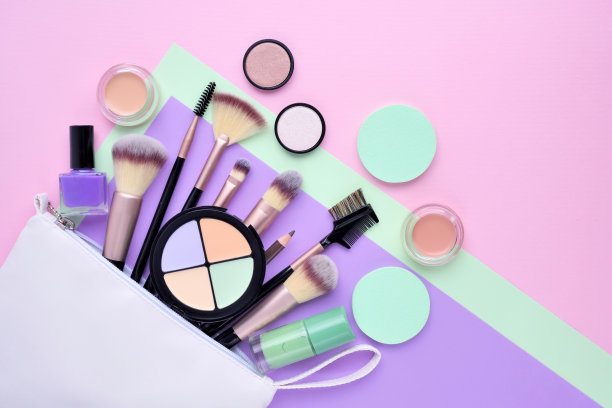 一个白色的化妆品包，化妆品溢出到一个彩色的背景。俯视图图片下载