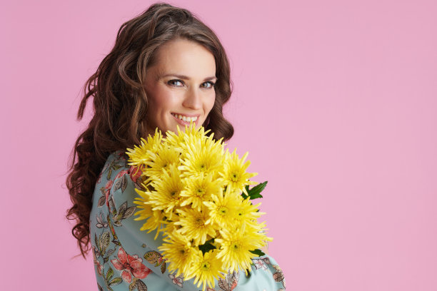 微笑时髦的女人与长波浪浅棕色的头发在粉红色图片下载